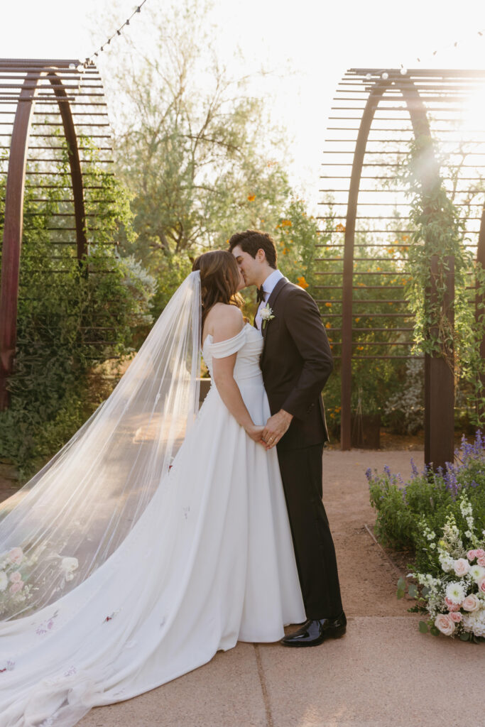 First kiss during an intimate wedding ceremony at Desert Botanical Garden in Phoenix