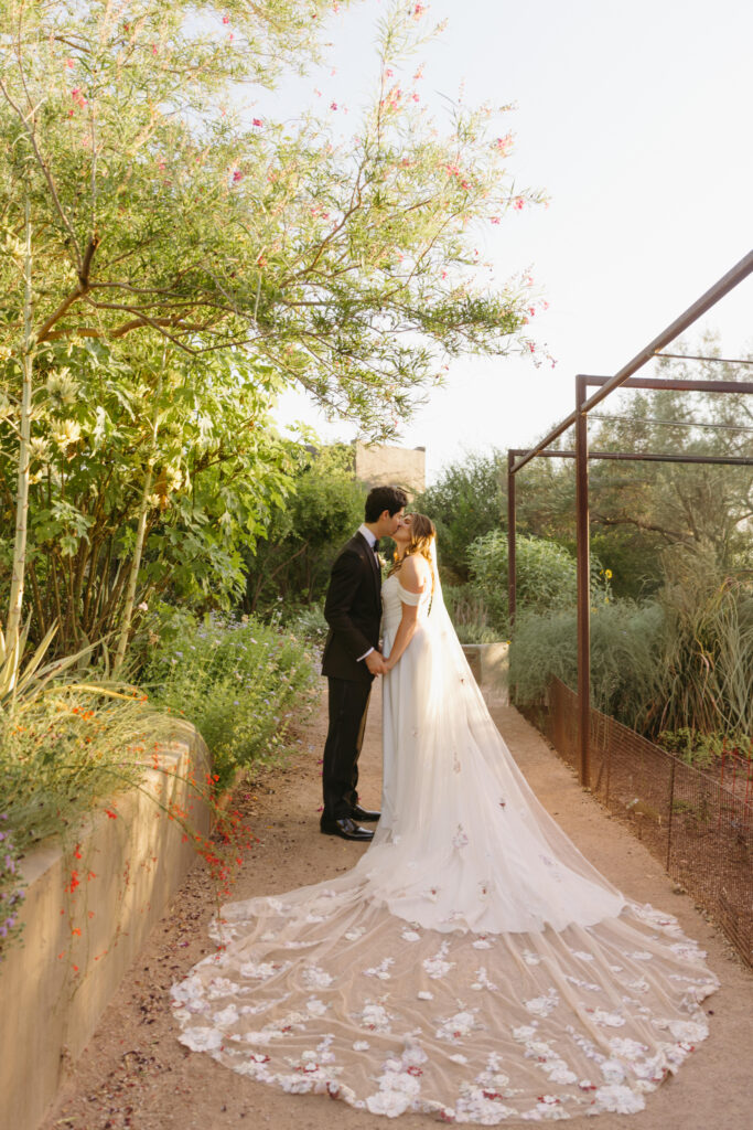 Couple embracing among desert blooms during their Desert Botanical Garden wedding
