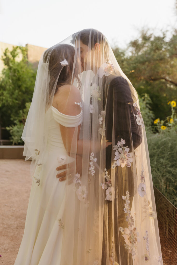 Couple embracing among desert blooms during their Desert Botanical Garden wedding