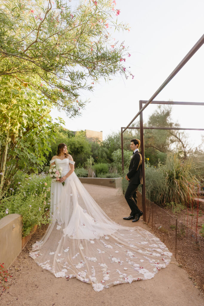 Couple embracing among desert blooms during their Desert Botanical Garden wedding