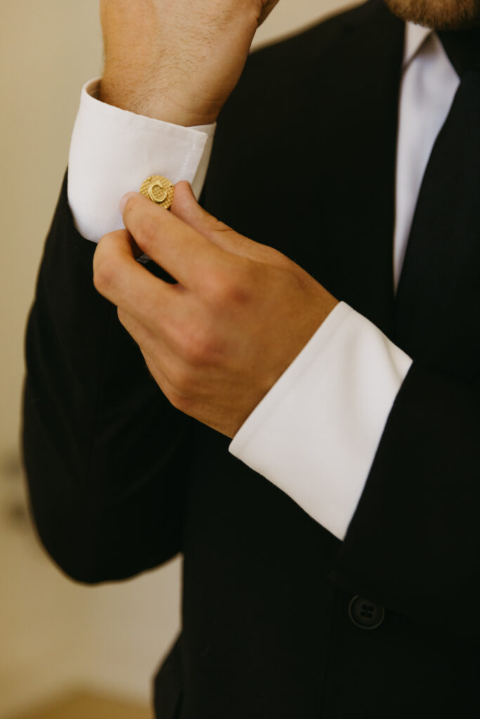 groom fixing cuff links 