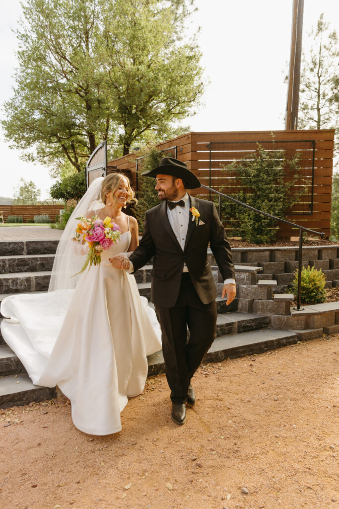 Bride and groom walking through pine trees at Cabins on Strawberry Hill
