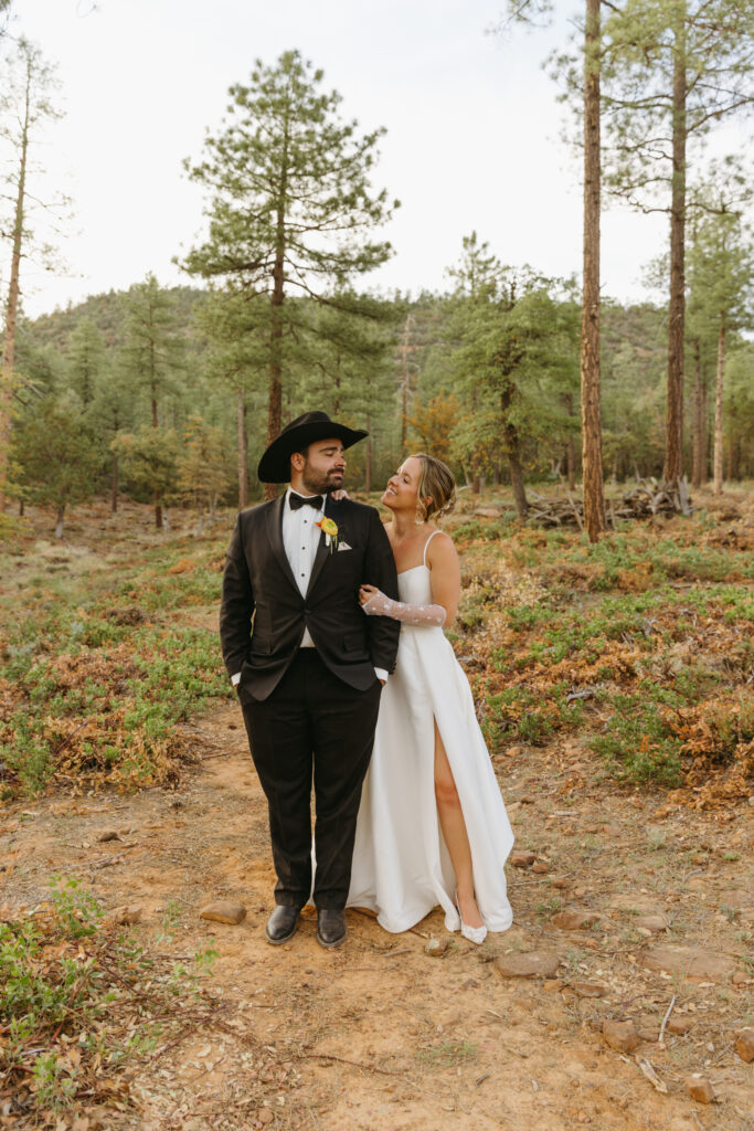Bride and groom walking through pine trees at Cabins on Strawberry Hill
