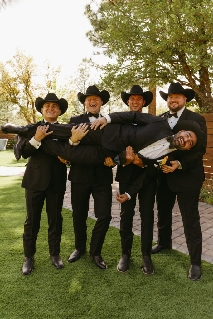 groomsmen lifting groom