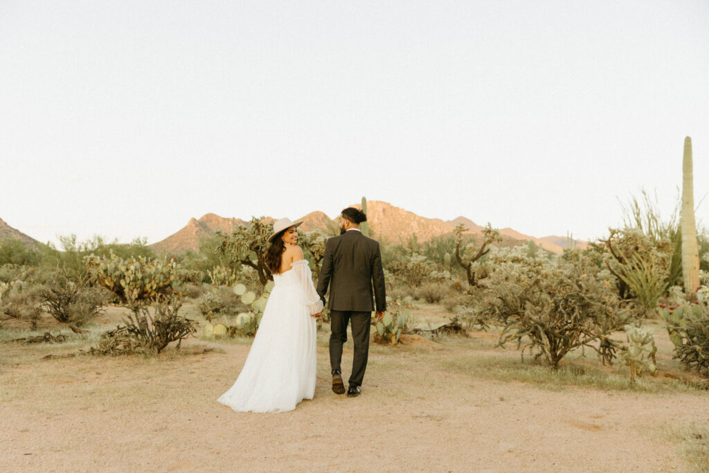 Bride and groom walking through the Sonoran Desert at JTH Tucson