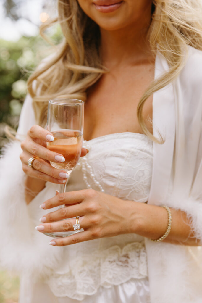 bride holding champagne wedding ring showing