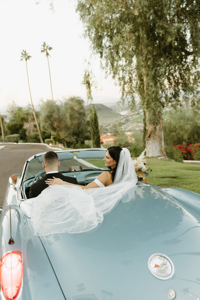 Newlyweds celebrating beside a vintage car at Different Pointe of View