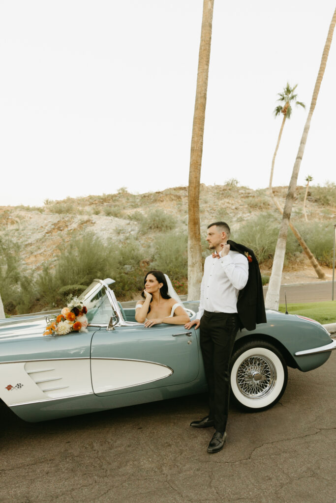 Newlyweds celebrating beside a vintage car at Different Pointe of View